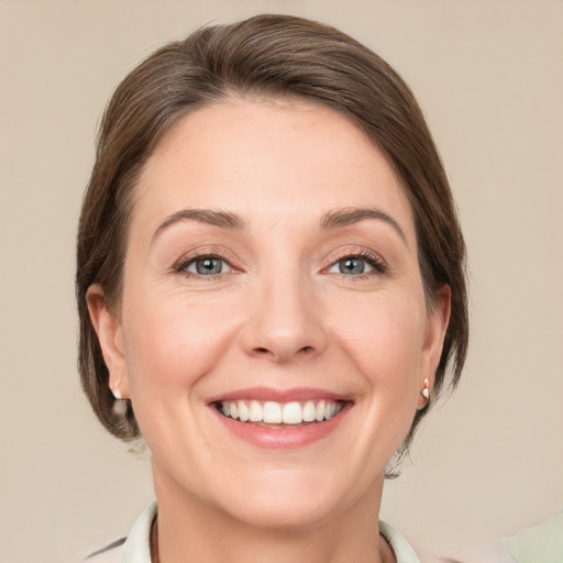 Joyful white adult female with medium  brown hair and grey eyes