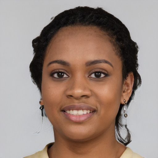 Joyful black young-adult female with long  black hair and brown eyes