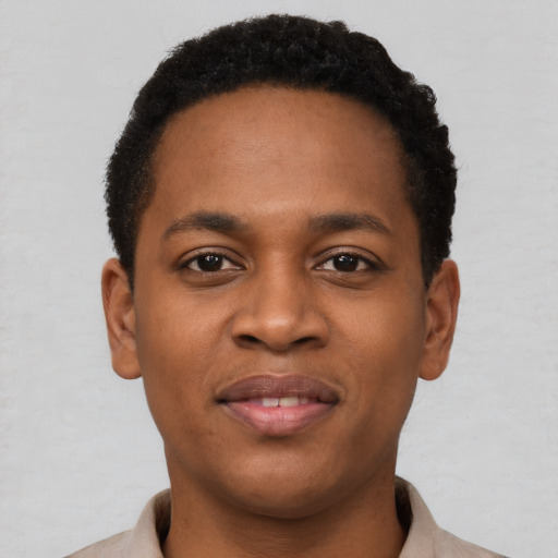 Joyful black young-adult male with short  black hair and brown eyes