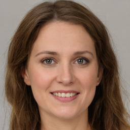 Joyful white young-adult female with long  brown hair and green eyes