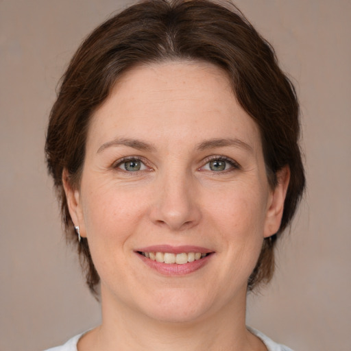 Joyful white adult female with medium  brown hair and brown eyes