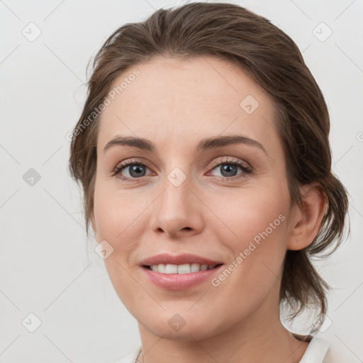 Joyful white young-adult female with medium  brown hair and grey eyes