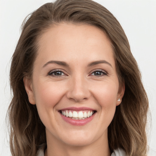 Joyful white young-adult female with long  brown hair and grey eyes