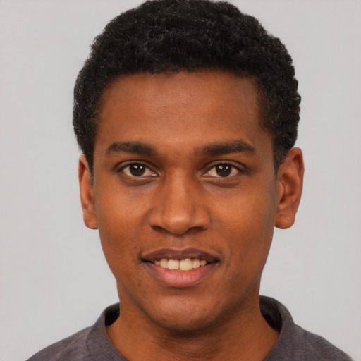 Joyful black young-adult male with short  black hair and brown eyes