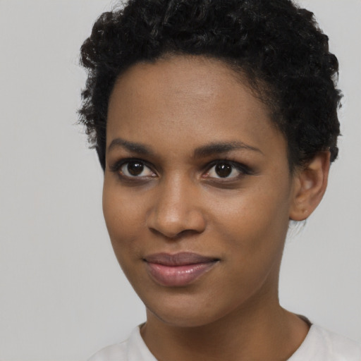 Joyful black young-adult female with short  brown hair and brown eyes