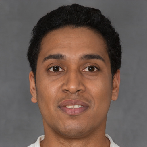Joyful latino young-adult male with short  brown hair and brown eyes