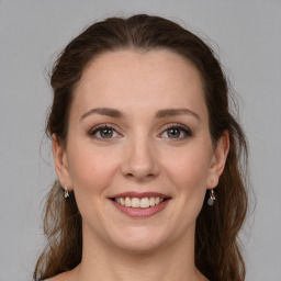 Joyful white young-adult female with medium  brown hair and grey eyes