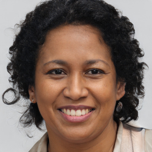 Joyful black young-adult female with long  brown hair and brown eyes
