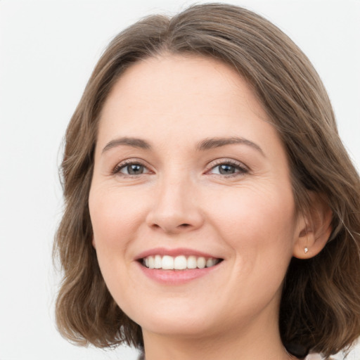 Joyful white young-adult female with medium  brown hair and green eyes