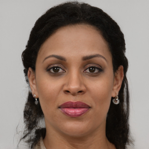 Joyful latino adult female with medium  brown hair and brown eyes