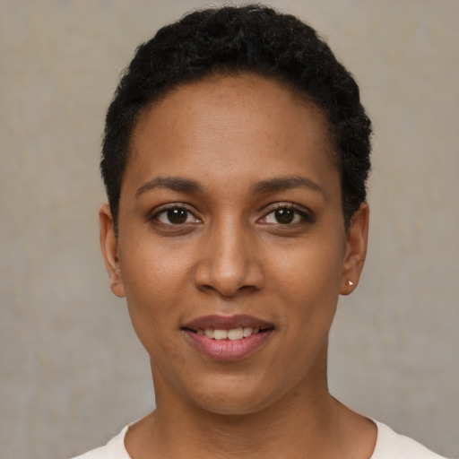 Joyful black young-adult female with short  black hair and brown eyes