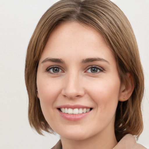 Joyful white young-adult female with medium  brown hair and green eyes