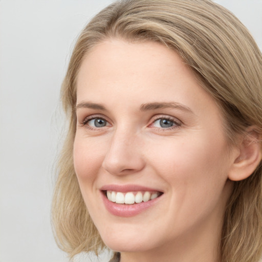 Joyful white young-adult female with long  brown hair and blue eyes