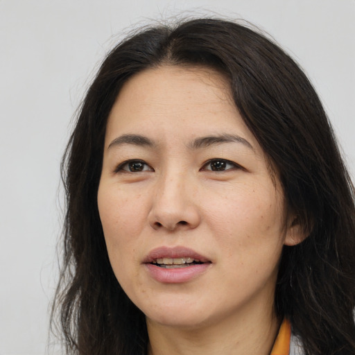 Joyful white adult female with long  brown hair and brown eyes