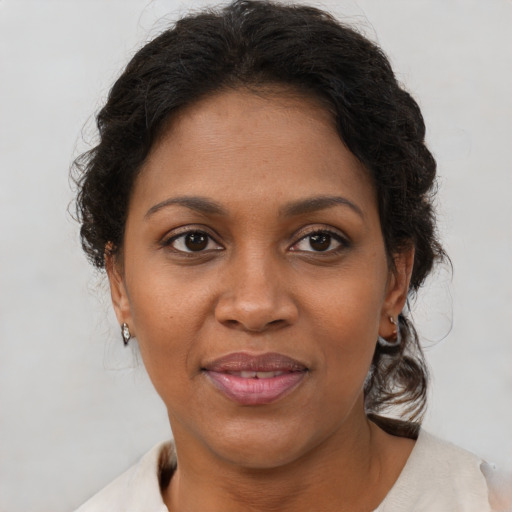Joyful black adult female with short  brown hair and brown eyes