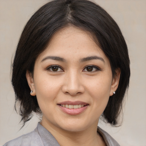 Joyful asian young-adult female with medium  brown hair and brown eyes