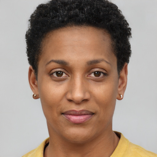 Joyful black young-adult female with short  brown hair and brown eyes