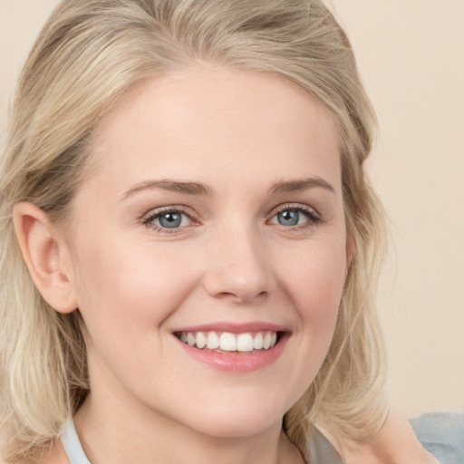 Joyful white young-adult female with medium  blond hair and blue eyes