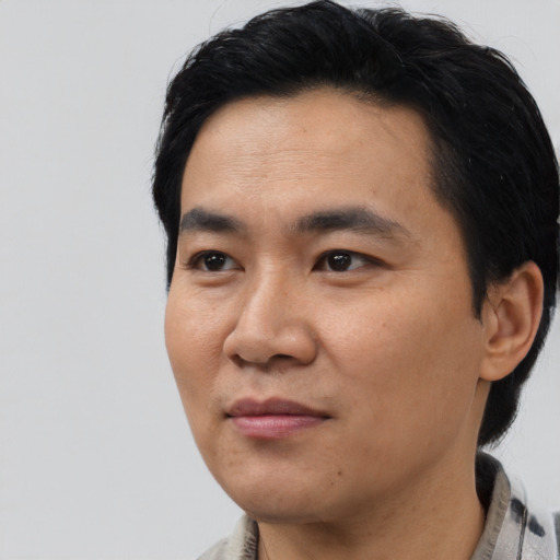 Joyful asian young-adult male with short  black hair and brown eyes