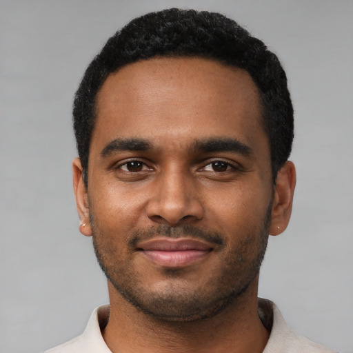 Joyful black young-adult male with short  black hair and brown eyes