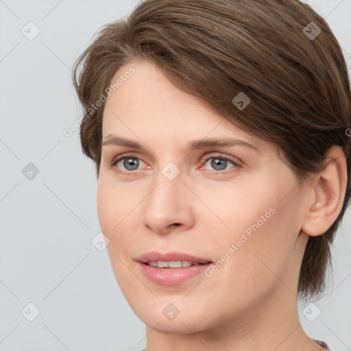 Joyful white young-adult female with medium  brown hair and grey eyes