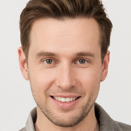 Joyful white young-adult male with short  brown hair and grey eyes