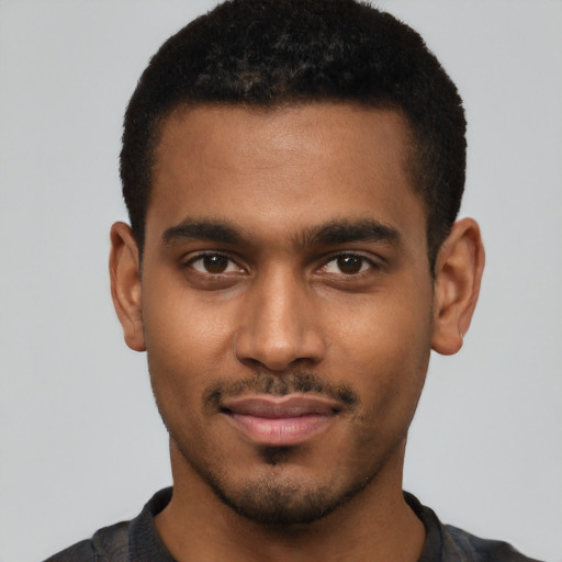 Joyful black young-adult male with short  brown hair and brown eyes