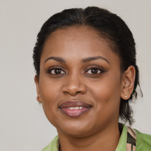 Joyful black young-adult female with short  brown hair and brown eyes