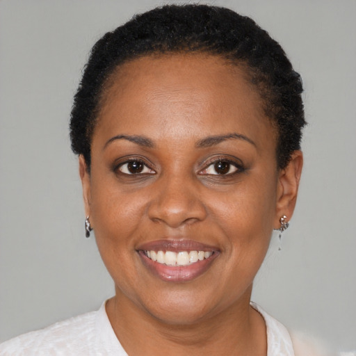 Joyful black adult female with short  black hair and brown eyes