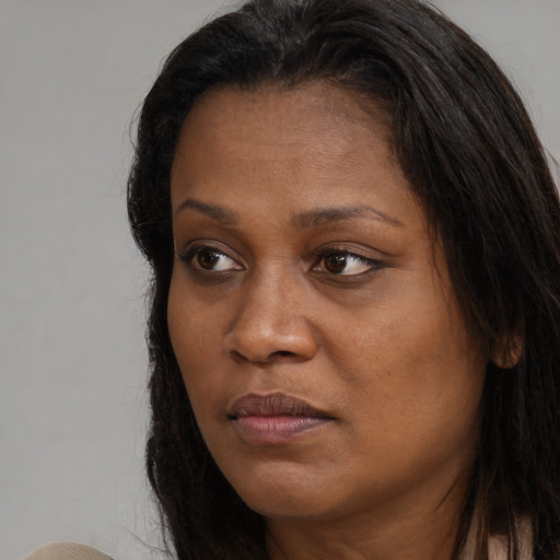 Joyful black adult female with long  brown hair and brown eyes