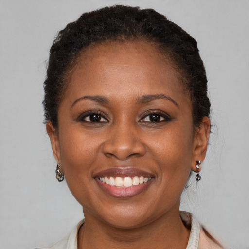 Joyful black young-adult female with short  brown hair and brown eyes
