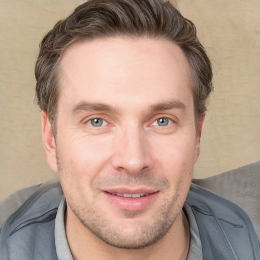 Joyful white young-adult male with short  brown hair and grey eyes