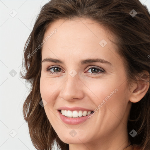 Joyful white young-adult female with long  brown hair and brown eyes