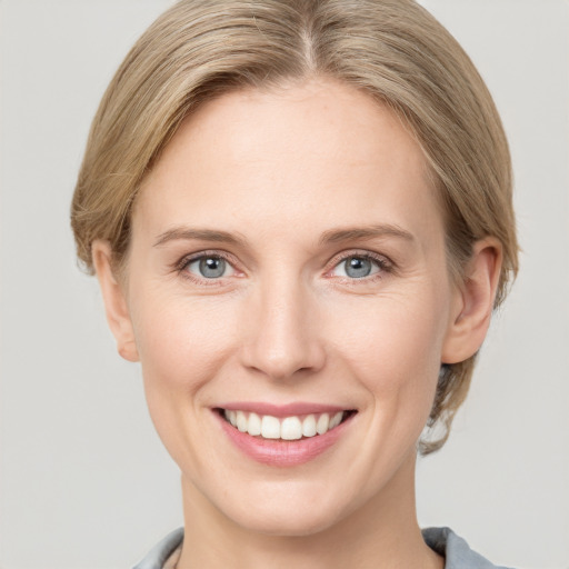 Joyful white young-adult female with short  brown hair and grey eyes