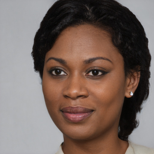 Joyful black young-adult female with short  black hair and brown eyes