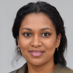 Joyful black young-adult female with long  brown hair and brown eyes