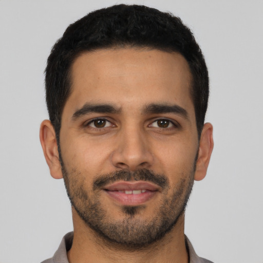 Joyful latino young-adult male with short  black hair and brown eyes