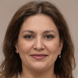 Joyful white adult female with medium  brown hair and grey eyes