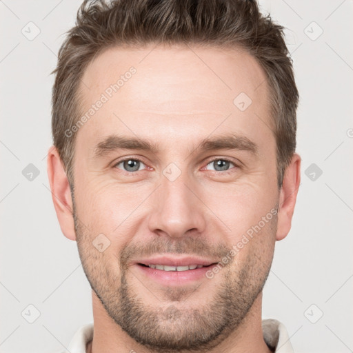 Joyful white young-adult male with short  brown hair and grey eyes