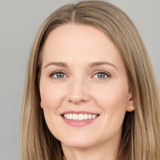 Joyful white young-adult female with long  brown hair and grey eyes