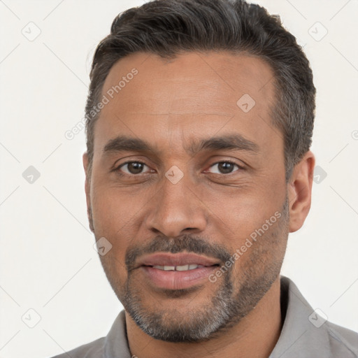 Joyful white adult male with short  black hair and brown eyes