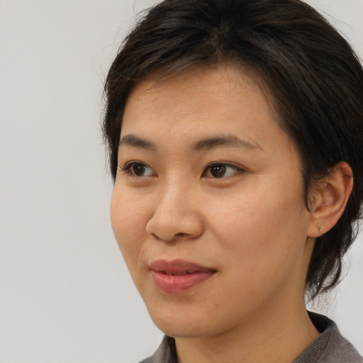 Joyful asian young-adult female with medium  brown hair and brown eyes