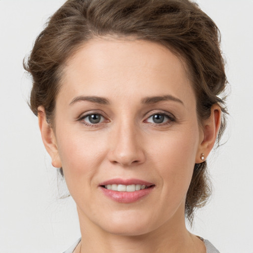 Joyful white young-adult female with medium  brown hair and grey eyes