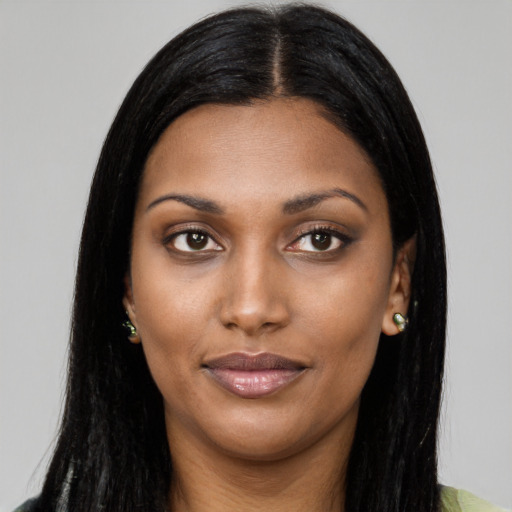 Joyful black young-adult female with long  black hair and brown eyes