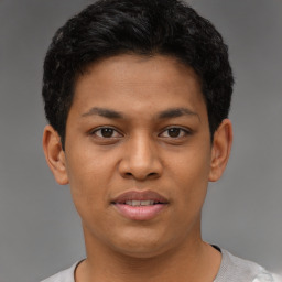 Joyful latino young-adult male with short  brown hair and brown eyes