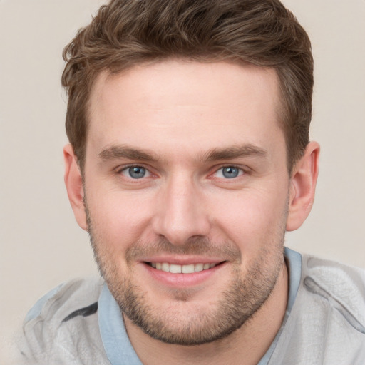 Joyful white young-adult male with short  brown hair and grey eyes