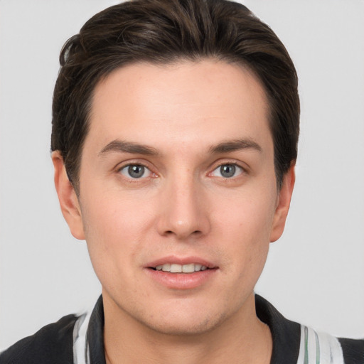 Joyful white young-adult male with short  brown hair and grey eyes