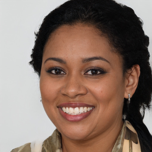 Joyful black young-adult female with long  brown hair and brown eyes