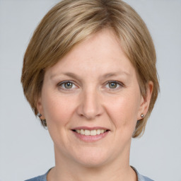 Joyful white adult female with medium  brown hair and grey eyes