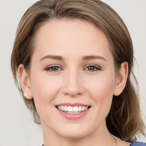 Joyful white young-adult female with medium  brown hair and grey eyes